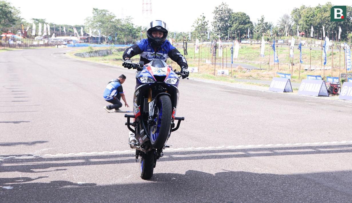 Atraksi motor yang dilakukan oleh, Muh Nur Iman  pada acara pembukaaan Yamaha Cup Race Seri 1 yang bertempat di Sirkuit Puncak Mario, Kabupaten Sidrap, Sulawesi Selatan. (Bola.com/Abdul Aziz)