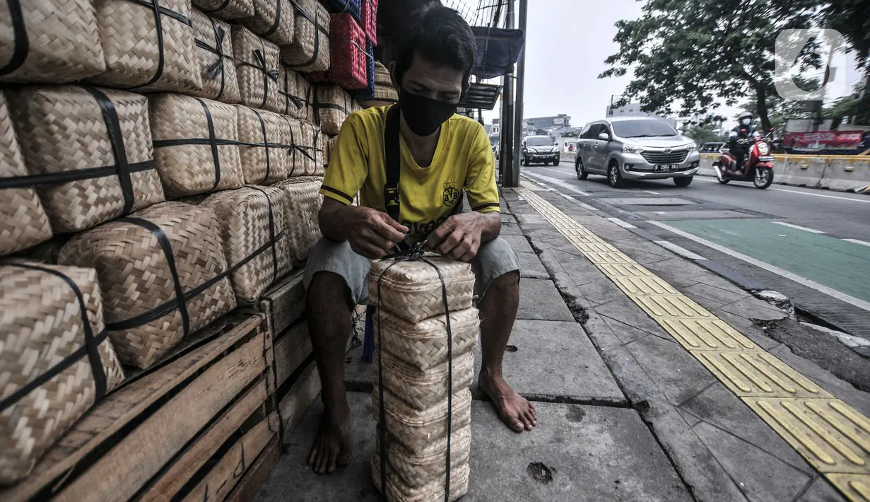 Pedagang mengambil besek bambu di kawasan Jatinegara, Jakarta, Senin (19/7/2021). Penjualan besek bambu yang digunakan sebagai wadah daging kurban saat Idul Adha pada tahun ini mengalami penurunan hingga 50 persen. (merdeka.com/Iqbal S. Nugroho)