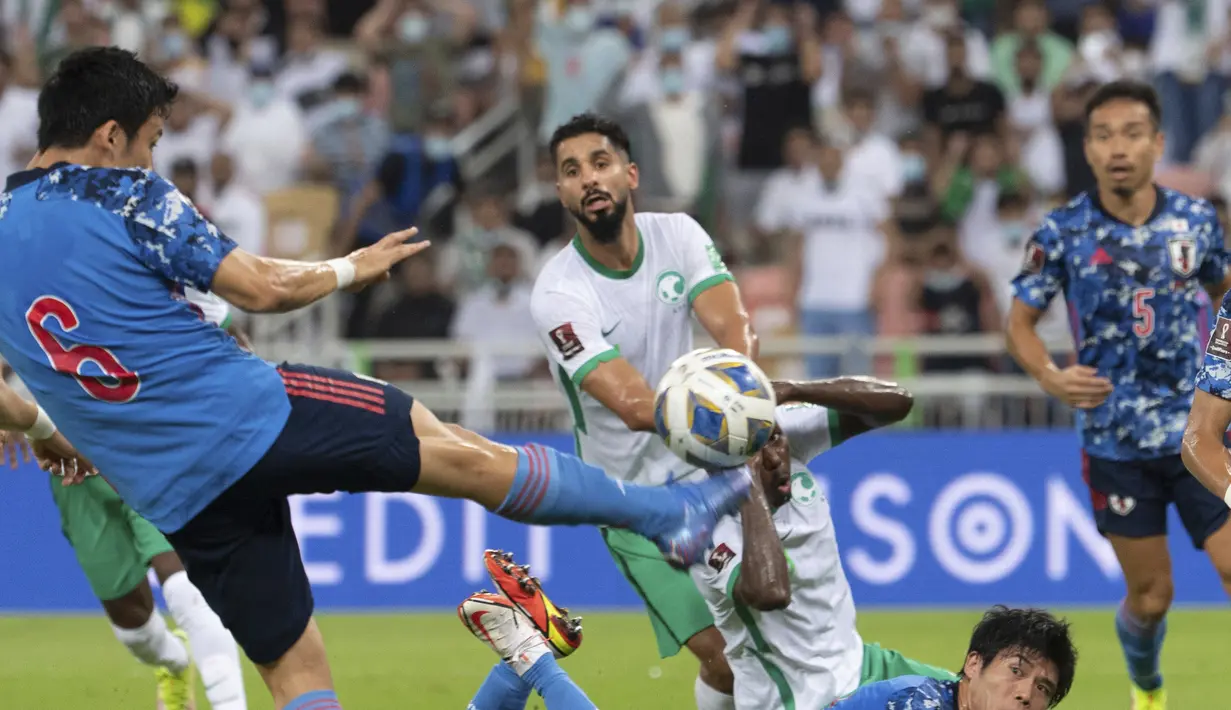 Gelandang Jepang, Wataru Endo menembak bola dari kawalan pemain Arab Saudi, Abdullah Madu dan Saleh Al-Shehri selama kualifikasi grup B zona Asia Piala Dunia Qatar 2022 di Stadion King Abdullah Sports City, Jeddah, Arab Saudi, Kamis (7/10/2021). Arab Saudi menang tipis atas Jepang 1-0. (AP Photo)