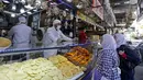 Warga membeli kudapan untuk berbuka puasa selama bulan suci Ramadan di Pasar Maidan, Damaskus, Suriah, Senin (26/4/2020). (Photo by LOUAI BESHARA/AFP)