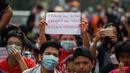 Seorang demonstran muda memegang poster saat ikut serta dalam demonstrasi menentang kudeta militer di Yangon, Myanmar pada Sabtu (6/2/2021). Ini adalah demonstrasi besar pertama sejak para jenderal merebut kekuasaan. (YE AUNG THU / AFP)