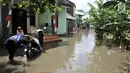 Warga mencuci motor di depan rumah saat banjir menggenangi kawasan Rawa Terate, Cakung Jakarta, Rabu (30/1). Banjir mencapai ketinggian pinggang orang dewasa terjadi sejak dini hari. (merdeka.com/Iqbal S. Nugroho)