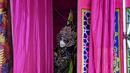 Seorang pemain Opera tradisional Tiongkok dari rombongan Sai Yong Hong melihat keluar dari belakang panggung selama perayaan Tahun Baru Imlek yang akan datang, di gudang Lhong 1919 di Bangkok (19/1/2022). (AFP/Lillian Suwanrumpha)