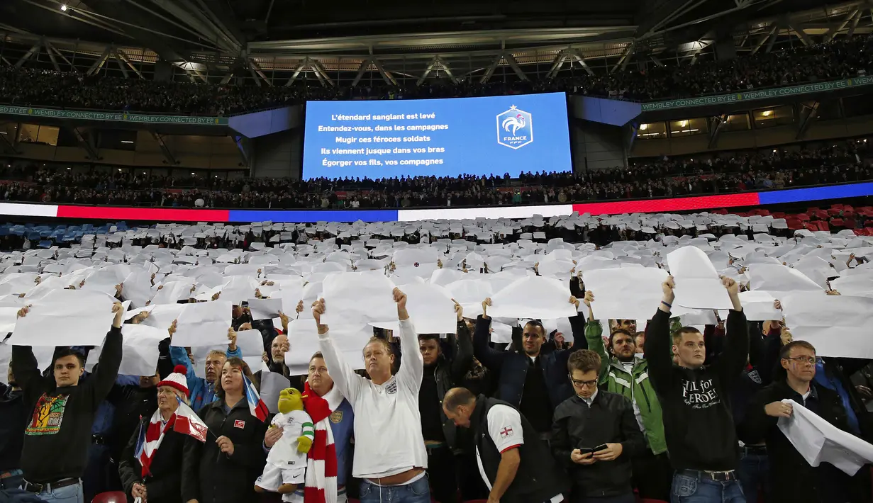 Suporter Inggris mengangkat kertas putih, yang merupakan bagian dari bendera Prancis pada laga Persahabatan antara Prancis vs Inggris di Stadion Wembley, London, Rabu(18/11/2015) dini hari WIB.  (AFP Photo/Ian Kington)