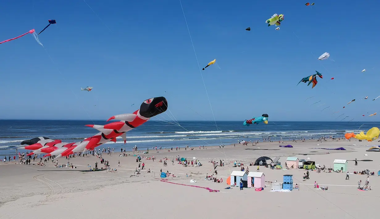 Sejumlah layang-layang berbagai bentuk dan warna memeriahkan Festival Layang-Layang Internasional ke-32 di pantai Berck-sur-Mer, Prancis utara, 18 April 2018. Uniknya, layang-layang terbuat dari kain parasut yang diikat puluhan tali. (Denis Charlet/AFP)