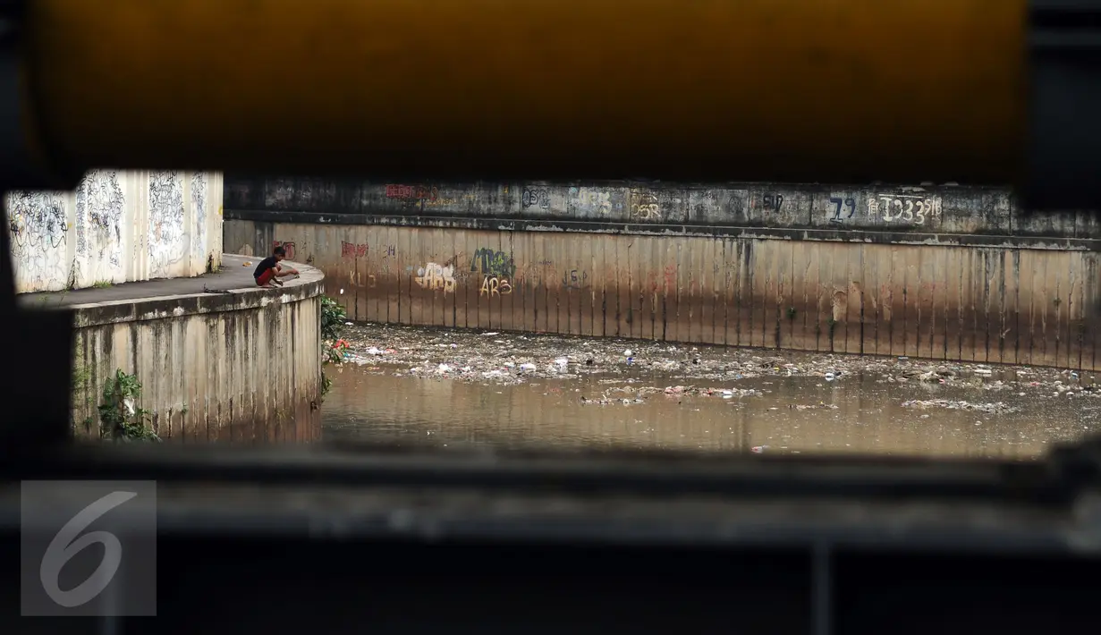 Warga memancing di Kali Krukut dekat TPU Karet Bivak Jakarta, Sabtu (5/11). Tumpukan sampah terlihat menggenang di sisi aliran Kali Krukut dan berbau. (Liputan6.com/Helmi Fithriansyah)