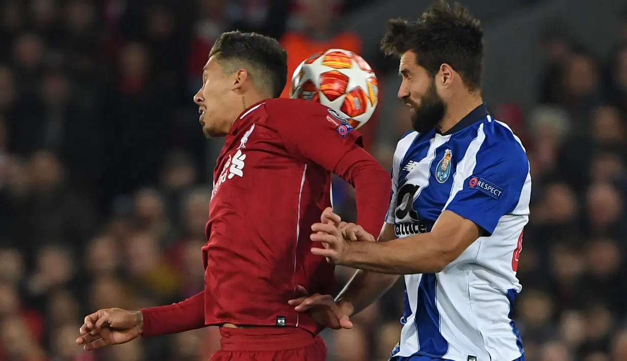 Gelandang Liverpool, Roberto Firmino berebut bola dengan bek Porto, Felipe dalam leg pertama perempat final Liga Champions di Stadion Anfield, Rabu (10/4/2019). Liverpool sukses mengalahkan Porto 2-0 melalui sumbangan Naby Keita dan Roberto Firmino. (Paul ELLIS / AFP)