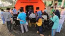 Pasien yang terpapar Covid-19 antre di luar tenda darurat yang didirikan di RSUP dr Sintanala, Kota Tangerang, Rabu (30/6/2021).  Pasien yang mengantre di luar tenda harus menunggu dengan menggunakan Kursi Roda. (Liputan6.com/Angga Yuniar)