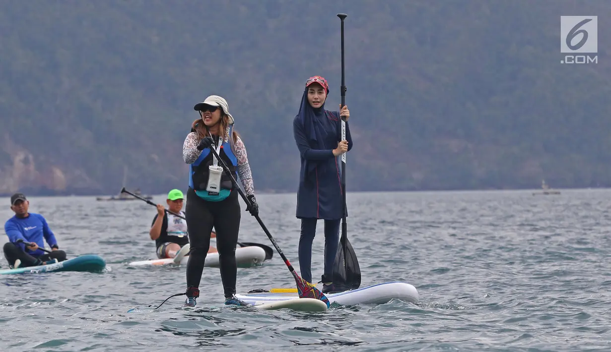 Istri bupati Trenggalek Novita Hardini bersama Istri Dirut BPJS Ketenagakerjaan Indri Suryawati saat Olah Raga Stand Up Paddle di Pantai Mutiara, Trenggalek, Jawa Timur, Sabtu (7/9/2019). Bermain Stand Up Paddle merupakan salah satu olah raga air atau wisata. (Liputan6.com/Herman Zakharia)