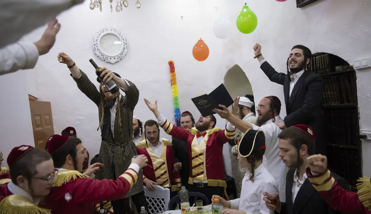 Yahudi Ultra-Ortodoks merayakan hari libur Yahudi Purim di lingkungan ultra-Ortodoks Mea Shearim, Yerusalem (28/2/2021). Hari libur Purim Yahudi memperingati keselamatan orang Yahudi dari genosida di Persia kuno, seperti yang diceritakan dalam Kitab Ester. (AP Photo/Oded Balilty)