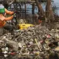 Petugas Dinas Kebersihan membersihkan sampah di pesisir Muara Angke, Jakarta, Kamis (29/10). Petugas menggunakan perahu untuk membersihkan sampah dari kawasan Muara Baru hingga Pantai Indah Kapuk. (Liputan6.com/Faizal Fanani)