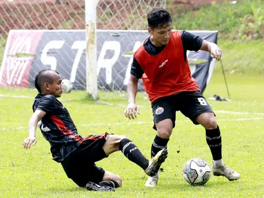 Riko SImanjuntak berusaha merebut bola dari kaki Syahrian Abimanyu saat sesi latihan Persija Jakarta di Lapangan Nirwana Park, Sawangan. (Bola.com/M iqbal Ichsan)