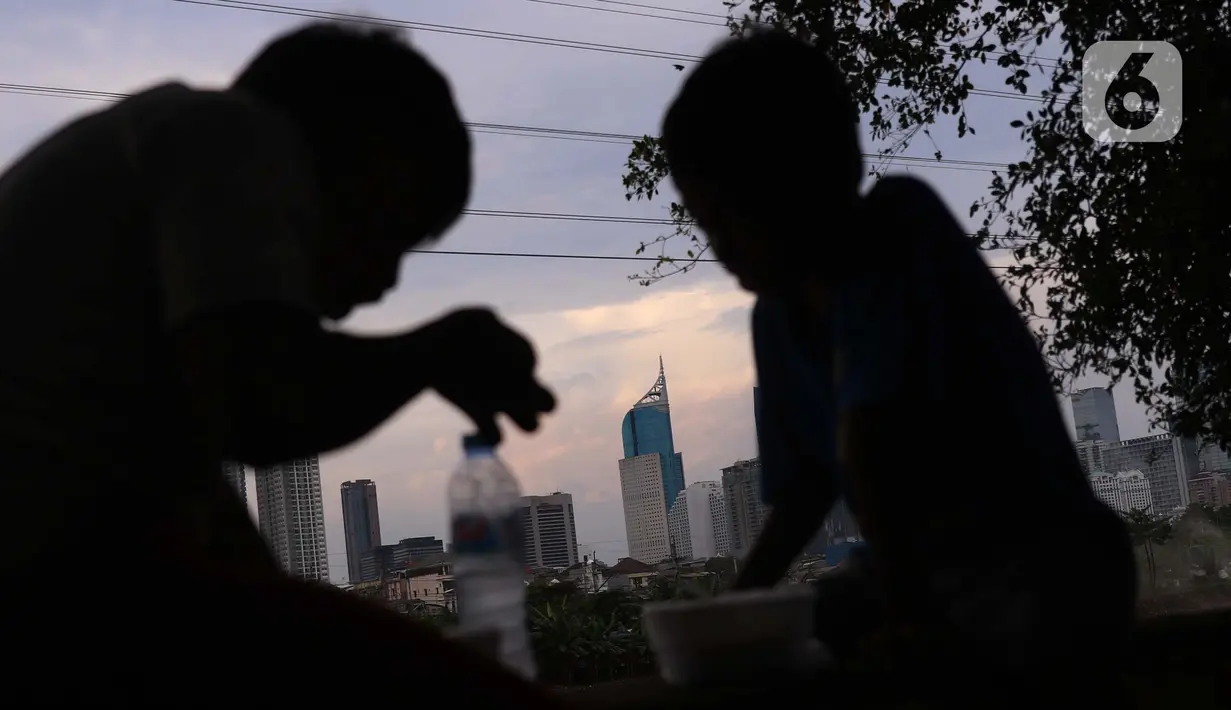 Anak-anak dengan latar gedung bertingkat menikmati makanan di Jakarta, Sabtu (19/3/2022). Bank Indonesia (BI) memperkirakan pertumbuhan ekonomi Indonesia akan meningkat lebih tinggi, pada kisaran 4,7 persen hingga 5,5 persen, dari pertumbuhan 3,69 persen pada 2021. (Liputan6.com/Angga Yuniar)
