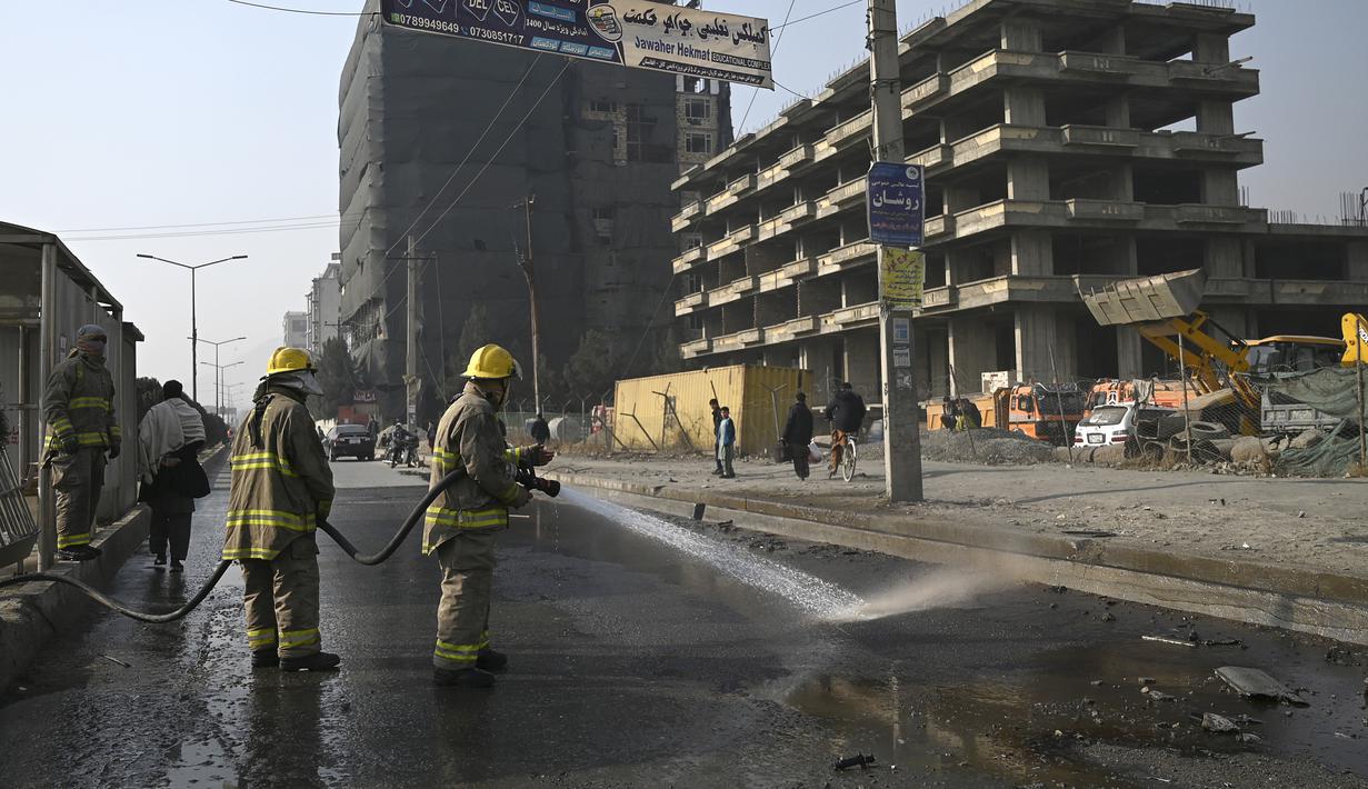 Petugas pemadam kebakaran membersihkan lokasi ledakan bom di Kabul (2/2/2021).  Dua orang tewas ketika ibu kota Afghanistan diguncang serangkaian bom mobil pada jam sibuk, kata para pejabat, sementara seorang polisi kendaraan menjadi sasaran dalam serangan di utara Kabul. (AFP/Bangun Kohsar)