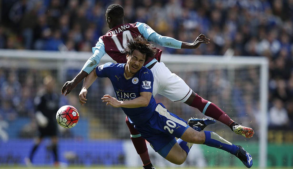 Gelandang Leicester, Shinji Okazaki, duel dengan pemain West Ham pada laga Liga Premier Inggris di Stadion King Power, Leicester, Minggu (17/4/2016). Imbang membuat jarak Leicester dengan Tottenham di posisi ke-2 menjadi 8 poin. (AFP/Adrian Dennis)