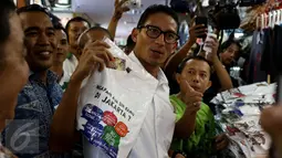 Cawagub DKI Jakarta, Sandiaga Uno membeli kaus bertuliskan I Love Jakarta saat menyambangi ITC Mangga Dua, Jakarta Utara, Kamis (3/11). Kedatangan Sandiaga disambut meriah pedagang dan pengunjung pusat perbelanjaan tersebut. (Liputan6.com/Gempur M Surya)