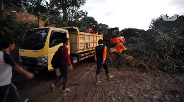 Warga melewati longsor yang menutup ruas jalan utama Cipanas-Cianjur akibat gempa bumi di kawasan Cugenang, Cianjur, Jawa Barat, Senin (21/11/2022). Longsor membawa sebuah angkot yang diduga berisi penumpang dan truk ke dalam jurang, evakuasi pun akan dilanjutkan esok hari. (merdeka.com/Arie Basuki)