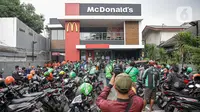 Kerumunan pengemudi ojek online saat antre mengambil pesanan di gerai cepat saji McDonald's Raden Saleh, Jakarta, Rabu (9/6/2021). Puluhan driver ojek online terlihat mengabaikan protokol kesehatan saat mengantre pesanan BTS Meal yang mulai dijual. (Liputan6.com/Faizal Fanani)