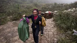 Dua pria berjalan menuju gua di Desa Zhongdong, Provinsi Guizhou, China (6/10/2016).  Menurut penduduk setempat gua tersebut juga dinilai sangat nyaman dan aman ketika cuaca buruk melanda. (AFP Photo / FredDufour)