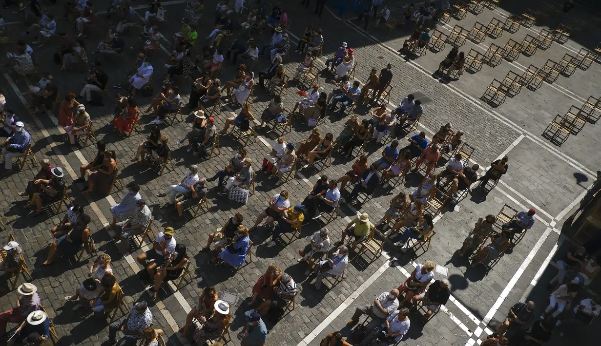 Orang-orang berkumpul di alun-alun Plaza del Ayuntamiento dan menjaga jarak untuk mencegah penyebaran COVID-19 selama festival music flamenco pada hari musim panas, di Pamplona, Spanyol utara, Kamis (26/8/2021).  (AP Photo/Alvaro Barrientos)