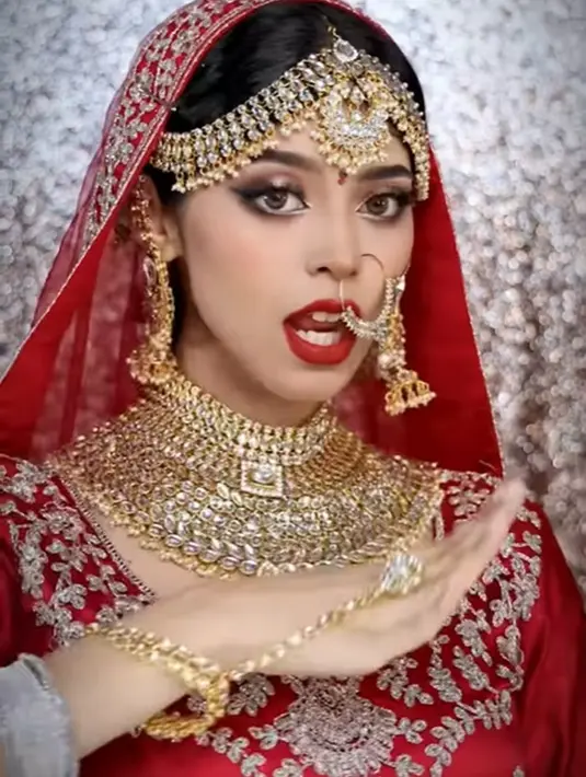 Jharna Bhagwani menampilkan full makeup yang luar biasa flawless dan dirinya yang mengenakan saree pengantin India berwarna merah. Berbagai aksesori khas pengantin perempuan India juga lengkap dikenakan olehnya. [Foto: Instagram/jharnabhagwani]