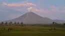 Gunung Semeru menyemburkan asap tipis terlihat dari desa Curah Kobokan di Lumajang, Jawa Timur, Rabu (8/12/2021).  Hingga Selasa (7/12/2021), ada 22 warga yang dinyatakan meninggal dunia akibat erupsi Gunung Semeru. (ADEK BERRY / AFP)