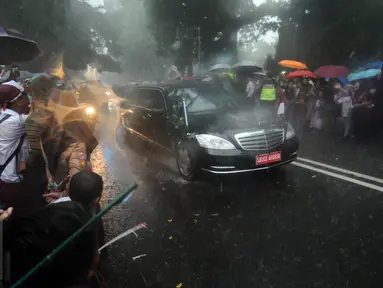 Pelajar dan warga menyambut kedatangan mobil bertuliskan Saudi Arabia di sekitar Istana Bogor, Rabu (1/3). Kedatangan Raja Salman bin Abdulaziz ke Istana Bogor disambut puluhan ribu pelajar dan warga. (Liputan6.com/Helmi Fithriansyah) 