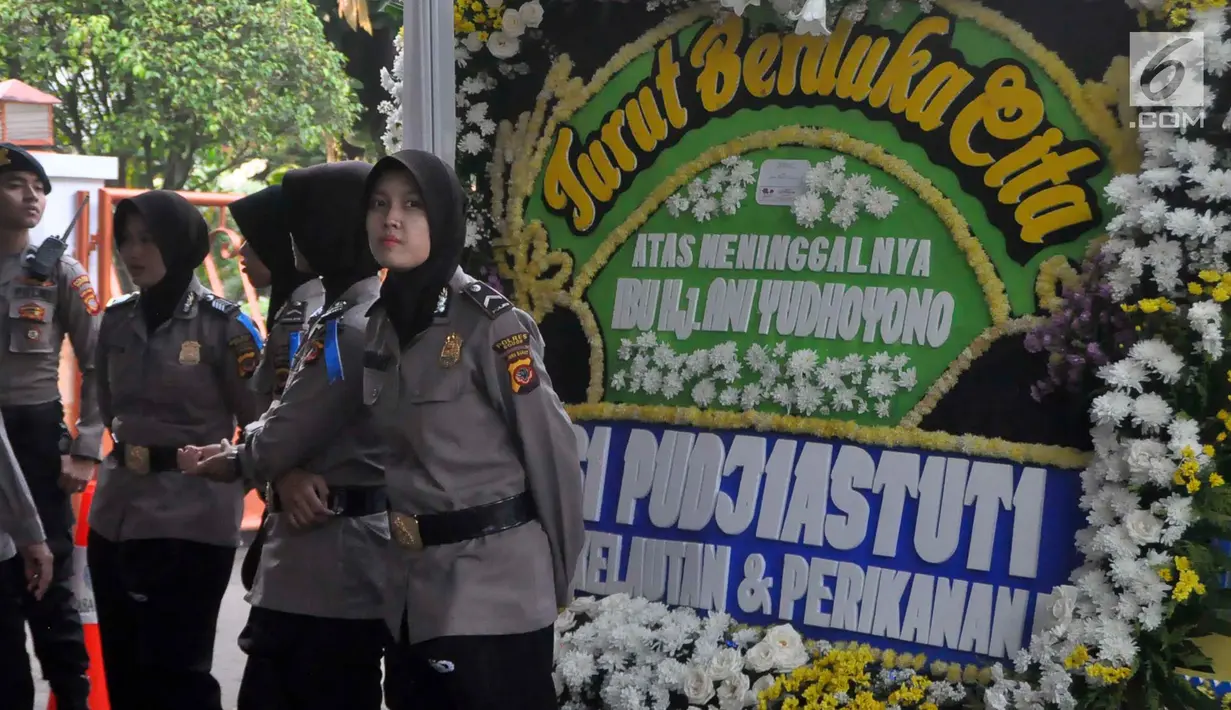 Polisi berdiri dekat karangan bunga ucapan bela sungkawa wafatnya Ani Yudhoyono menghiasi kawasan Puri Cikeas, Bogor, Jawa Barat, Minggu (2/6/2019). Istri Presiden ke-6 RI Susilo Bambang Yudhoyono (SBY) itu rencananya akan dimakamkan di TMP Kalibata pada siang ini. (Liputan6.com/Immanuel Antonius)