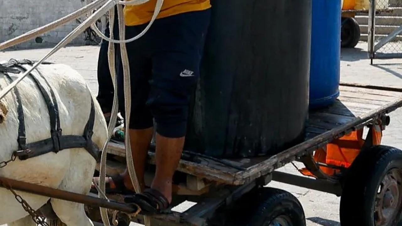 Jeriken, drum hingga tempat penampung air (toren) mereka bawa untuk mengisi air dari keran umum di tengah konflik Hamas dengan Israel di Khan Younis.