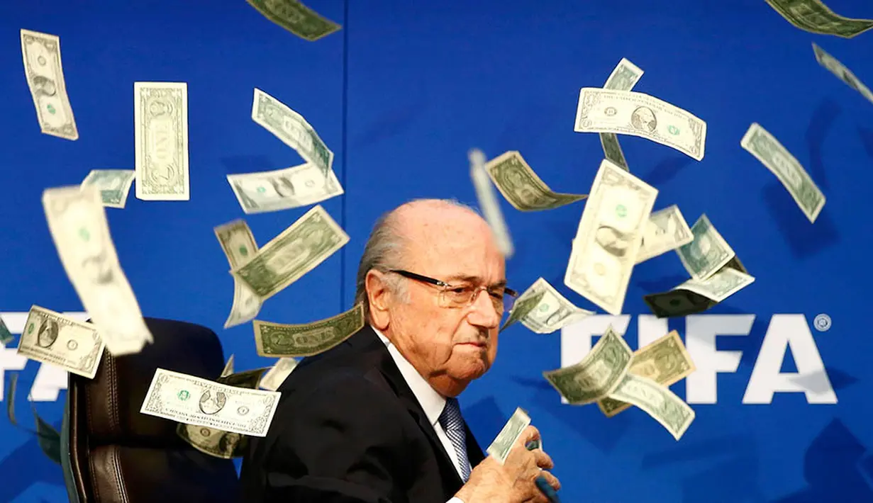 Komedian Inggris, Lee Nelson melempar uang kertas ke arah Sepp Blatter di markas FIFA di Zurich, Swiss. Tingkah Nelson itu dilakukan sebagai bentuk protesnya. (Reuters/Arnd Wiegmann)