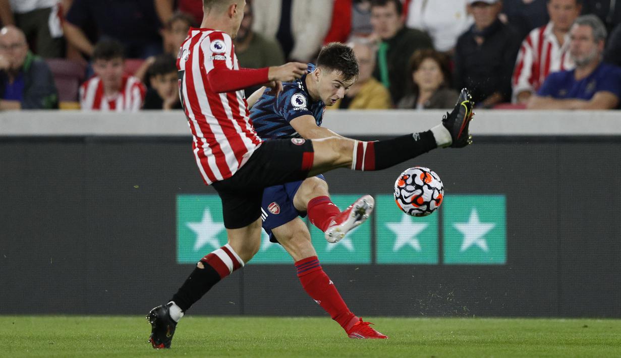 Arsenal berusaha samakan kedudukan di awal babak kedua. The Gunners mendapatkan peluang di menit ke-51. Kieran Tierney (kanan) berusaha mengumpan ke Emile Smith Rowe untuk diteruskan ke gawang Brentford. Sayangnya bola masih bisa dihalau oleh kiper David Raya. (Foto: AFP/Adrian Dennis)