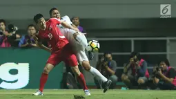 Pemain belakang Indonesia U-23, Ricky Fajrin S (kanan) berebut bola dengan pemain Korea Utara, Jo Sol Song pada laga PSSI Anniversary Cup 2018 di Stadion Pakansari, Kab Bogor, Senin (30/4). Babak pertama imbang 0-0. (Liputan6.com/Helmi Fithriansyah)