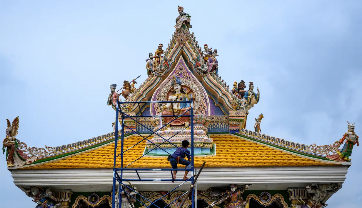 Pekerja meletakkan sentuhan terakhir pada atap Kuil Buddha Wat Pariwat atau Kuil David Beckham di Bangkok, Thailand, Selasa (14/7/2020). Kuil David Beckham dihiasi dengan patung-patung superhero, karakter komik, makhluk mitos dan imajiner, serta tokoh dunia. (Mladen ANTONOV/AFP)