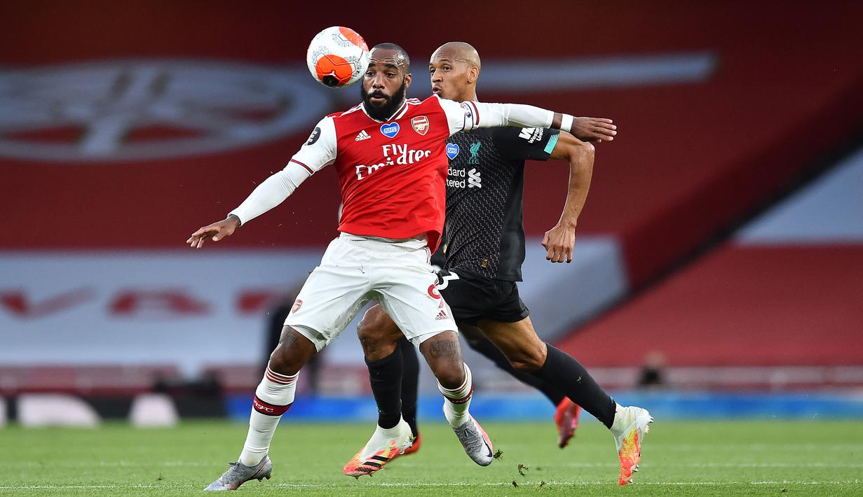 Striker Arsenal,Alexandre Lacazette, berebut bola dengan gelandang Liverpool, Fabinho, pada pada laga lanjutan Premier League pekan ke-36 di Emirates Stadium, Kamis (16/7/2020) dini hari WIB. Arsenal menang 2-1 atas Liverpool. (AFP/Glyn Kirk/pool)