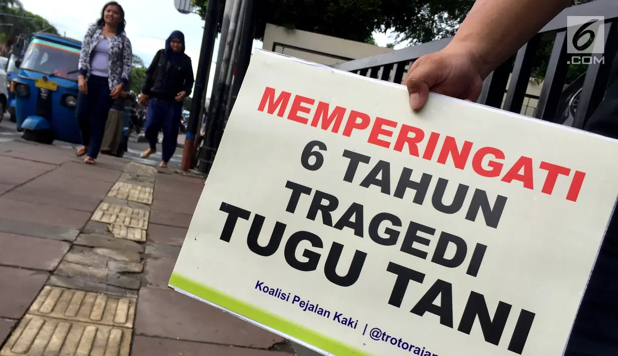 Aktivis Koalisi Pejalan Kaki membawa poster berisi pesan-pesan saat tabur bunga di sekitar Halte Tugu Tani, Jakarta, Senin (22/1). (Liputan6.com/Immanuel Antonius)