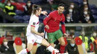 Pemain Turki Caglar Soyuncu berebut bola dengan bintang Portugal Cristiano Ronaldo pada laga play off kualifikasi Piala Dunia 2022 di Stadion Do Dragao, Porto, Portugal, Jumat, 25 Maret. Portugal menang 3-1. (AP Photo/Luis Vieira)