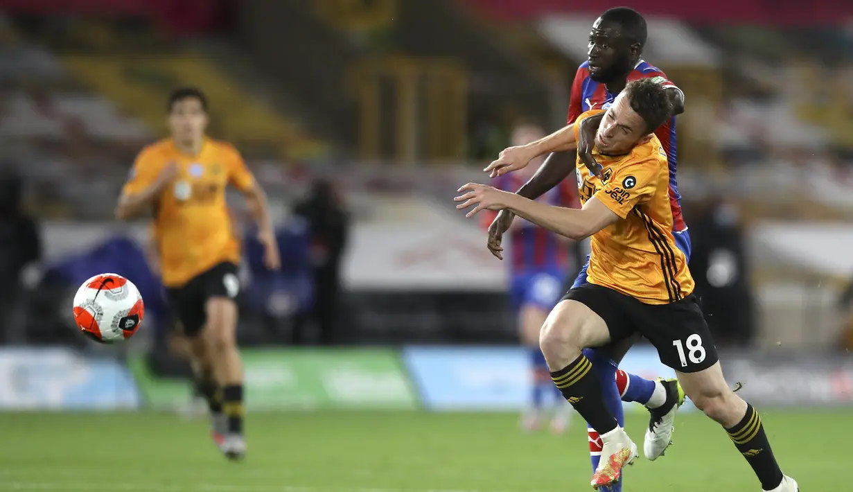 Pemain Wolverhampton Wanderers Diogo Jota berebut bola dengan pemain Crystal Palace Cheikhou Kouyate pada pertandingan Premier League di Molineux Stadium, Wolverhampton, Inggris, Senin (20/7/2020). Wolverhampton Wanderers menang 2-0. (AP Photo/Martin Rickett, Pool)