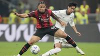 Pemain AC Milan, Noah Okafor, berebut bola dengan pemain Lazio, Daichi Kamada, pada giornata ketujuh Serie A 2023/2024 di Stadion San Siro, Mingggu (1/10/2023). AC Milan berhasil unggul terlebih dahulu melalui gol Christian Pulisic sementara Noah Okafor mengunci kemenangan Rossoneri di akhir babak kedua. (AP Photo/Luca Bruno)