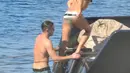 Zac Efron dan Michelle Rodriguez  menaiki tangga usai menyeburkan diri ke pantai, Pulau Sardinia, Italia, Selasa (8/7/2014) (mzn.com)