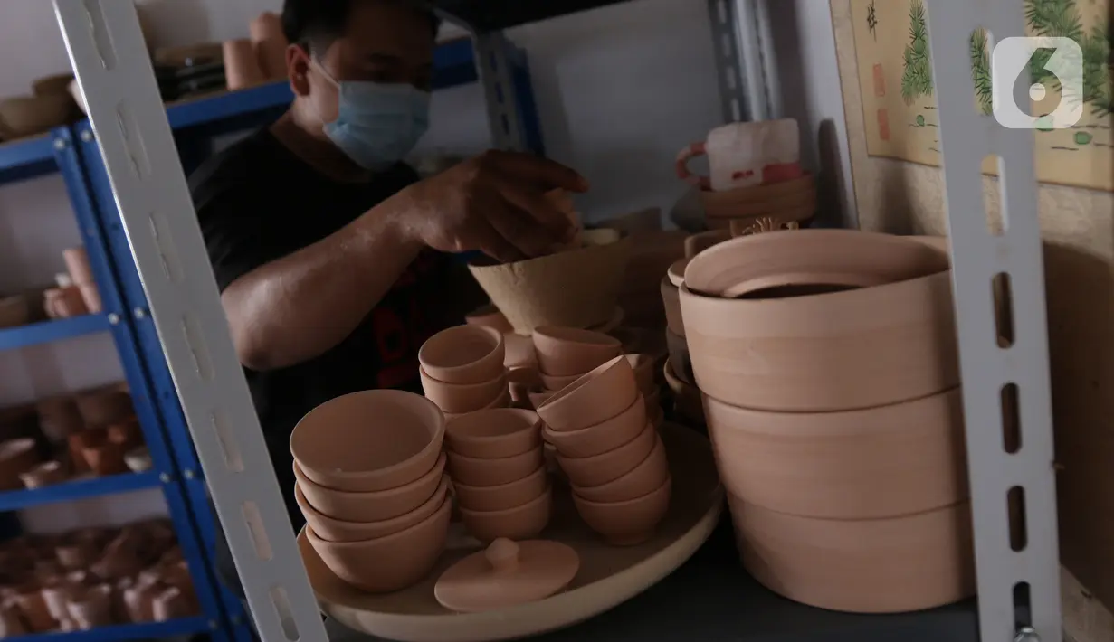 Perajin, Damar (39), menata produk berbahan tanah liat di Jurang Mangu, Tangerang Selatan, Banten, Sabtu (16/1/2021). Produksi keramik rumahan tersebut dipasarkan hingga luar pulau Jawa dengan harga Rp100 ribu sampai Rp300 ribu tergantung ukuran dan tingkat kesulitannya. (Liputan6.com/Angga Yuniar)