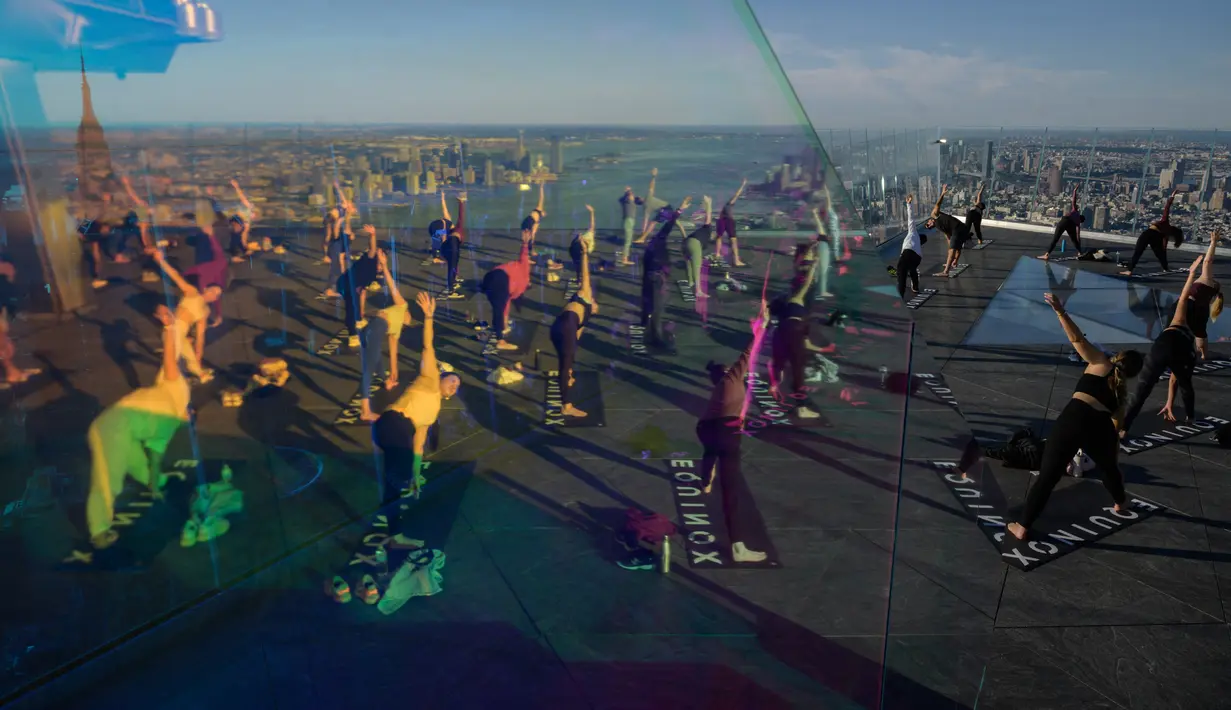 Praktisi yoga menghadiri kelas di Edge Observation Deck, Manhattan, New York, Amerika Serikat, Kamis (17/6/2021). Edge Observation Deck memiliki ketinggian 1.131 kaki (345 meter). (Ed JONES/AFP)