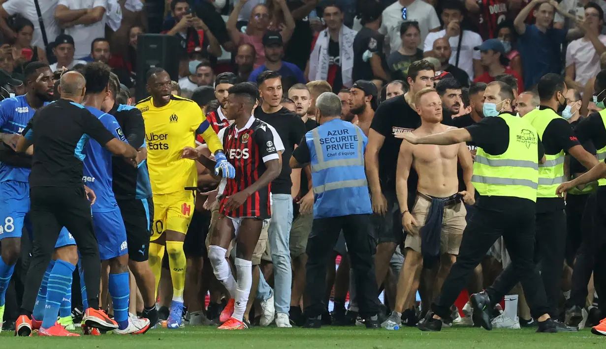 Kejadian tersebut diperparah dengan sikap para pemain Marseille lainnya yang menendang bola ke arah suporter Nice hingga makin memicu amarah mereka untuk bersama-sama turun ke lapangan. (Foto: AFP/Valery Hache)
