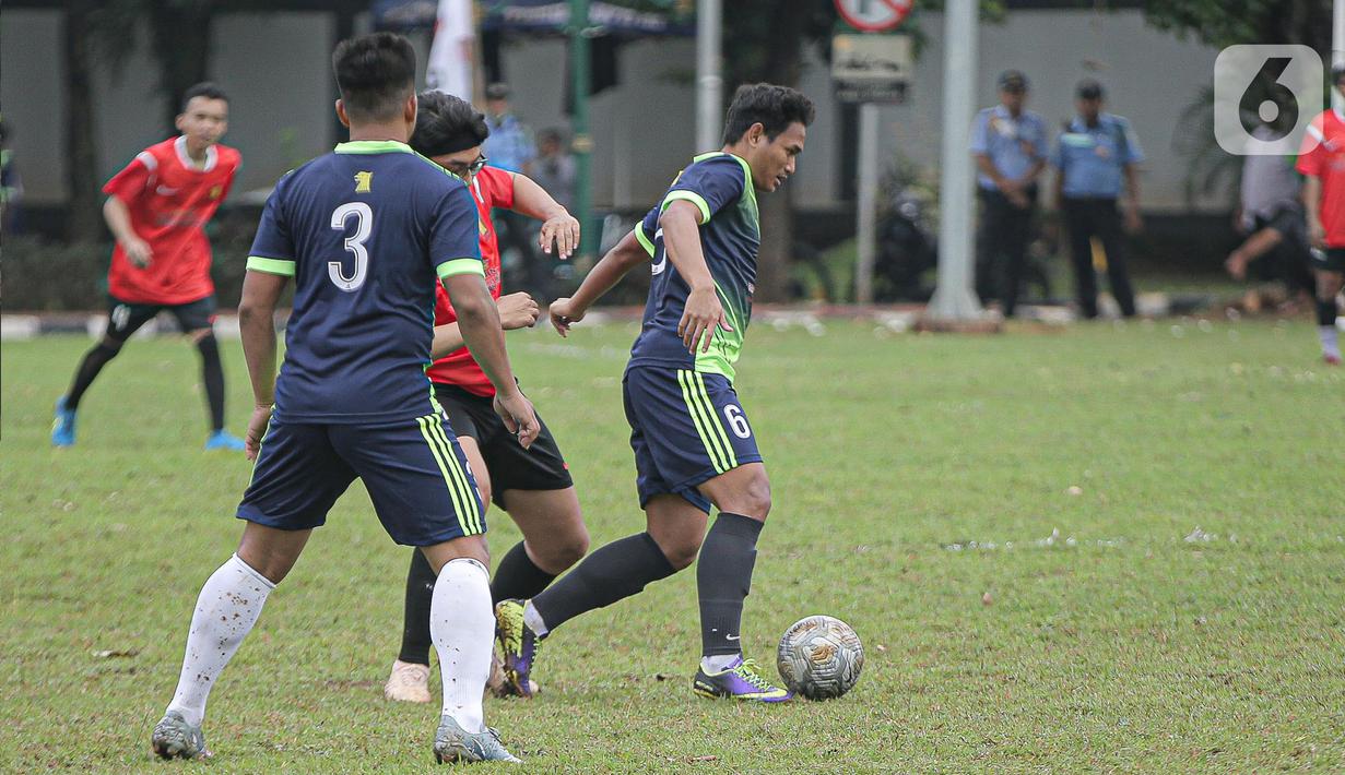 Pemain tim fraksi Gerinda berebut bola dengan pemain tim Gedung Taman DPR saat pertandingan dalam rangkaian HUT Gerindra ke-15 di Lapangan Sepak bola DPR RI, Jakarta, Selasa (31/1/2023). Sejumlah kegiatan dilaksanakan dalam rangkaian HUT Gerinda Ke-15 yang digelar sederhana dan tidak secara foya-foya. (Liputan6.com/Faizal Fanani)