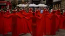 Sejumlah orang yang menutup diri dengan kain warna merah menarik perhatian warga saat memprotes kekejaman terhadap hewan sebelum dimulainya Festival San Fermin. (AP Photo/Alvaro Barrientos)