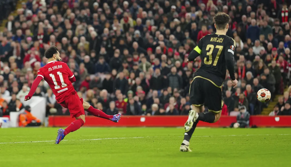 Pemain Liverpool, Mohamed Salah (kiri) mencetak gol ke gawang ketiga timnya ke gawang Sparta Praha pada laga leg kedua 16 besar Liga Europa 2023/2024 di Anfield, Liverpool, Inggris, Jumat (15/03/2024). (AP Photo/Jon Super)