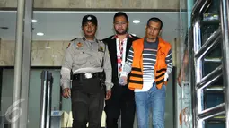 Rekan dekat Komisi III DPR RI, I Putu Sudiartana, Suhemi (kanan) dikawal petugas usai menjalani pemeriksaan perdana di Gedung KPK, Jakarta, (15/7). Nilai suap senilai Rp 300 miliar untuk pembangunan 12 ruas jalan. (Liputan6.com/Helmi Afandi)