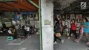 Warga melintas di lorong yang diisi sejumlah pelukis di trotoar Kawasan Glodok, Jakarta, Selasa (15/5). Para pelukis ini menawarkan jasanya dengan kisaran harga Rp 150 ribu sampai dengan Rp 5 juta. (Liputan6.com/Herman Zakharia)