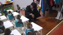 Seorang pria menjadi pengajar para monyet di sekolah pelatihan kebun binatang di Dongying, China timur, 26 Januari 2016. Belasan monyet dilatih di sekolah itu sebagai bagian dari perayaan Tahun Monyet yang mulai pada 8 Februari. (AFP PHOTO/WANG Zhao)