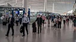 Orang-orang tiba di Bandara Internasional Ibu Kota Beijing untuk melakukan perjalanan menjelang liburan "Golden Week" pada 30 September 2020. Gelombang liburan melanda China yang warganya merayakan libur panjang, yang dikenal dengan Golden Week. (NICOLAS ASFOURI / AFP)
