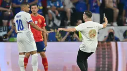 Penyerbu lapangan berhasil menghindari keamanan saat ia berlari ke arah bintang Prancis Kylian Mbappe, dengan wasit terpaksa menghentikan pertandingan. (MIGUEL MEDINA / AFP)